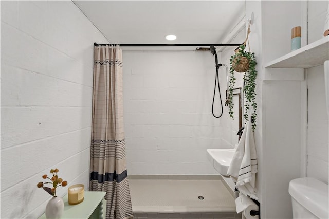 bathroom featuring walk in shower and toilet