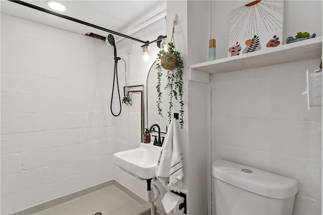 bathroom with sink, toilet, and tiled shower