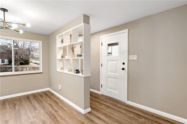doorway to outside with hardwood / wood-style flooring and an inviting chandelier