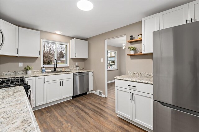 kitchen featuring sink, dark wood-type flooring, stainless steel appliances, and white cabinets
