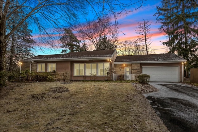 ranch-style home with a yard and a garage