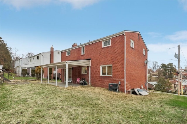 back of house featuring central AC unit, a yard, and a patio area