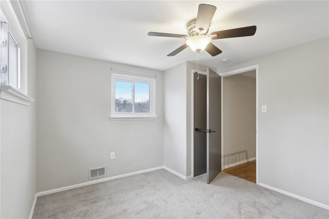 unfurnished bedroom with light colored carpet and ceiling fan