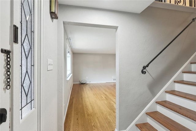 stairway with wood-type flooring and a wealth of natural light