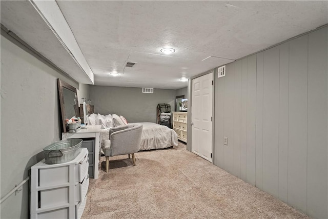 bedroom with light colored carpet and wooden walls