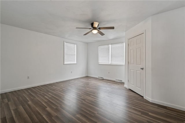 empty room featuring dark hardwood / wood-style flooring and ceiling fan