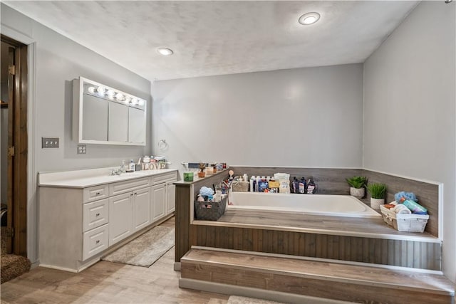 bathroom featuring vanity, hardwood / wood-style floors, and a bathtub