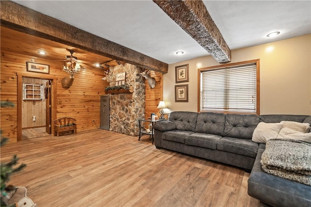 living room featuring beamed ceiling, hardwood / wood-style floors, ceiling fan, and wood walls