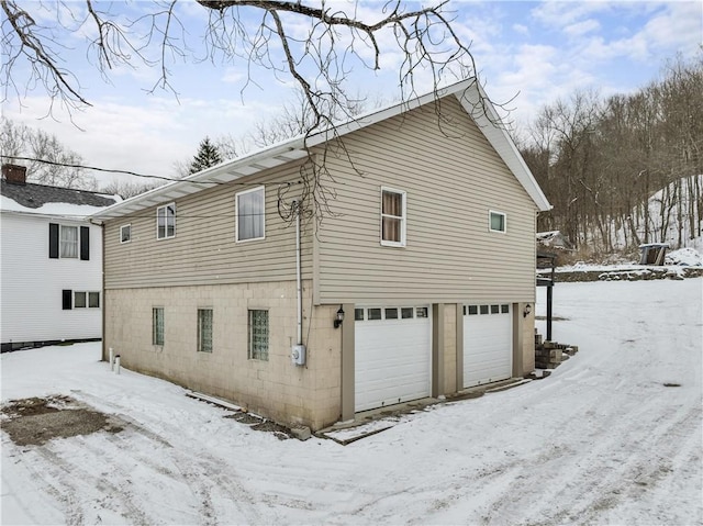 view of snow covered exterior with a garage