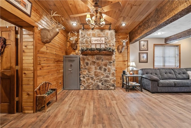 interior space with ceiling fan, wood-type flooring, wooden ceiling, beamed ceiling, and wood walls