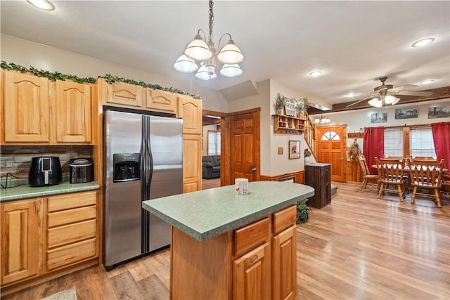 kitchen featuring ceiling fan with notable chandelier, a center island, light hardwood / wood-style floors, stainless steel fridge with ice dispenser, and decorative light fixtures