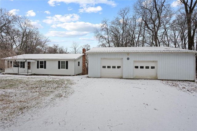 view of front of home with a garage and an outbuilding