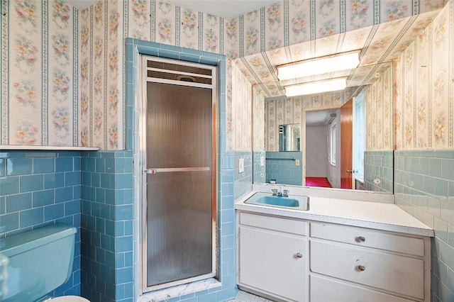 bathroom with tile walls, vanity, and walk in shower