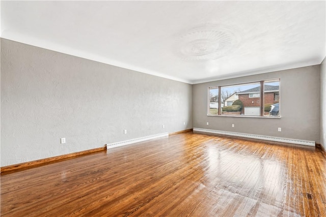 spare room with hardwood / wood-style floors and a baseboard radiator