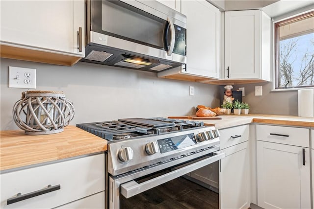 kitchen featuring stainless steel appliances, white cabinetry, and hardwood / wood-style flooring