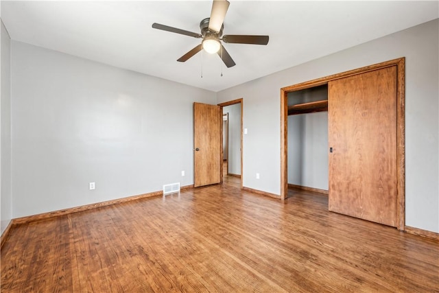 unfurnished bedroom featuring hardwood / wood-style floors, a closet, and ceiling fan