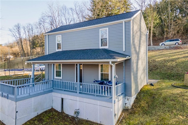 view of front of house featuring a porch, a front yard, and a trampoline