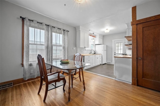 dining room with sink and light wood-type flooring