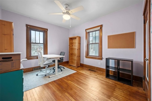 office area with plenty of natural light, hardwood / wood-style floors, and ceiling fan