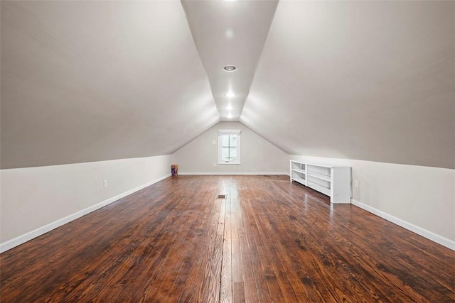 bonus room featuring dark hardwood / wood-style flooring, vaulted ceiling, and built in features