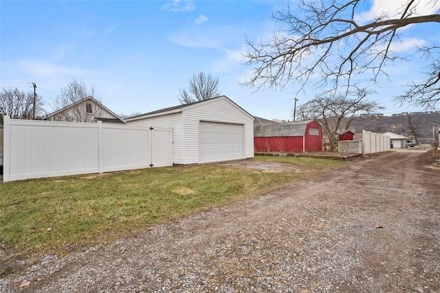 view of yard featuring a garage and an outbuilding