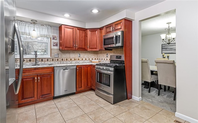 kitchen featuring backsplash, decorative light fixtures, sink, and appliances with stainless steel finishes