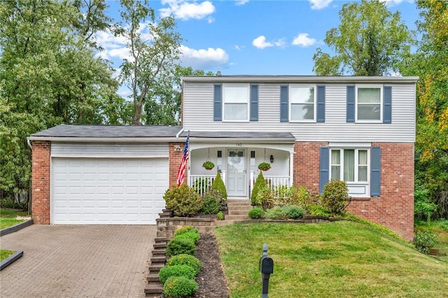 view of front of home with a garage, a front yard, and covered porch