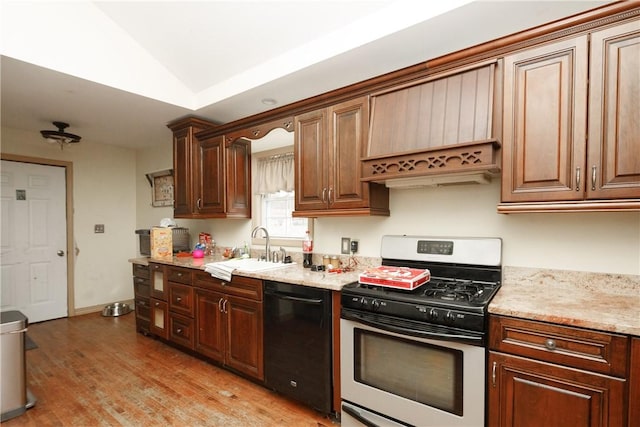 kitchen with lofted ceiling, sink, stainless steel gas range, black dishwasher, and light hardwood / wood-style floors