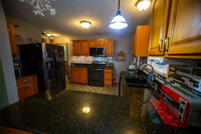 kitchen featuring sink, pendant lighting, decorative backsplash, and black appliances