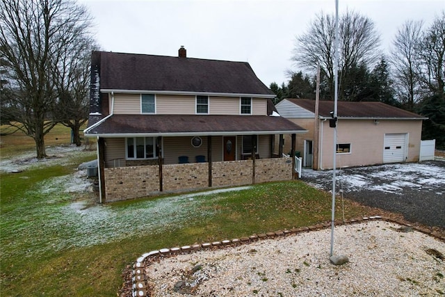 view of front of property featuring a garage, a front yard, and a porch