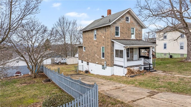 view of side of property featuring a yard and covered porch