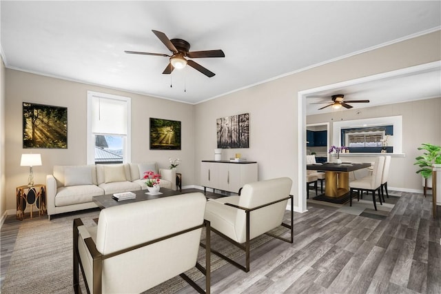 living room with hardwood / wood-style flooring, ornamental molding, and ceiling fan