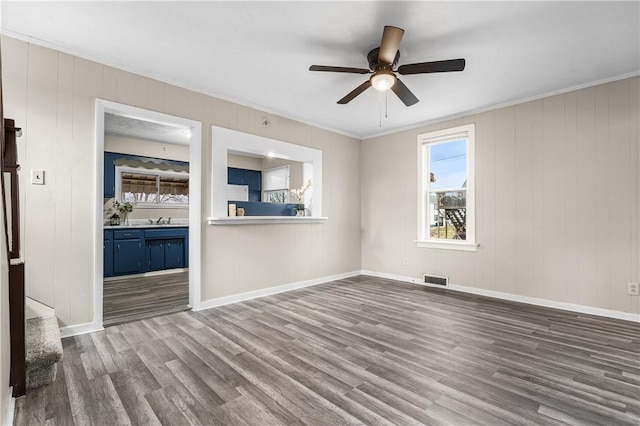 unfurnished living room with hardwood / wood-style floors, sink, and ceiling fan