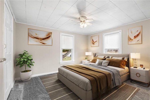 bedroom with ornamental molding, ceiling fan, and dark carpet