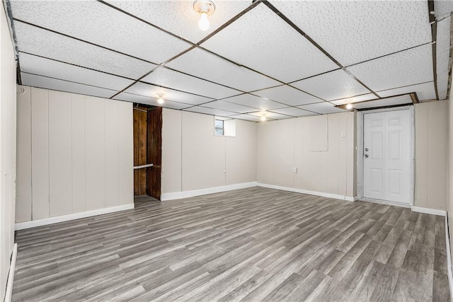 basement featuring hardwood / wood-style flooring and a paneled ceiling