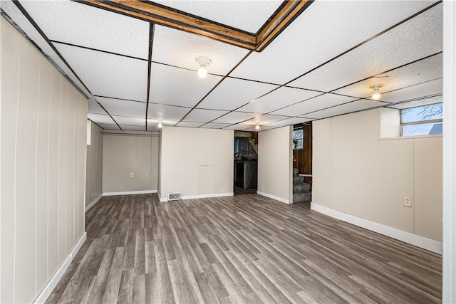 basement featuring wood-type flooring and a drop ceiling