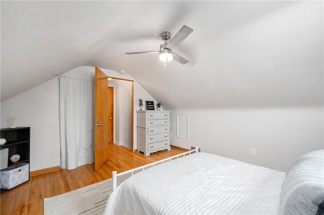 bedroom with lofted ceiling, hardwood / wood-style floors, and ceiling fan