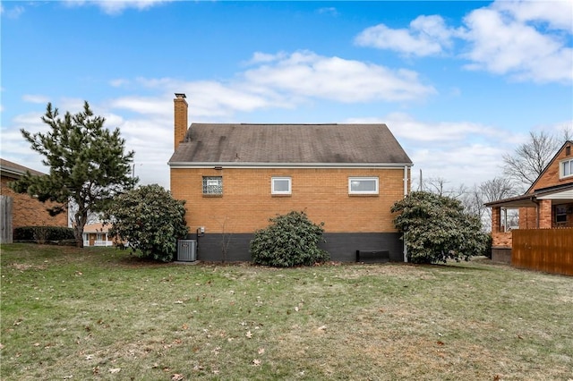 rear view of property with a yard and central AC