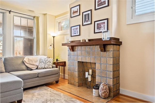 living room with hardwood / wood-style floors and a brick fireplace