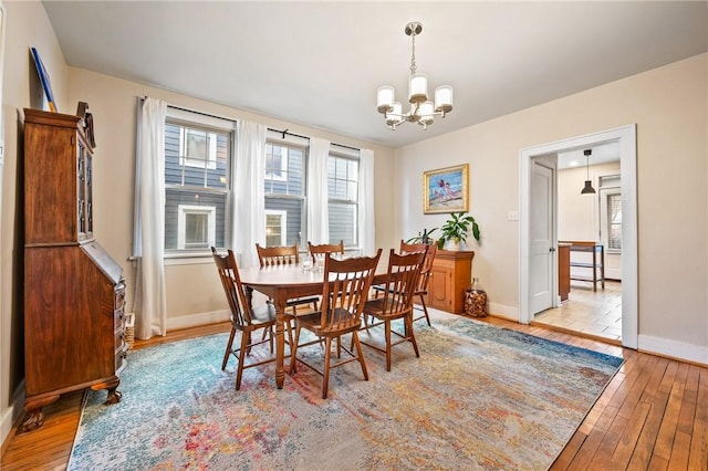 dining area with light hardwood / wood-style floors and a chandelier