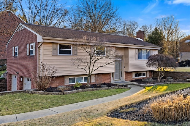 bi-level home with a garage and a front yard