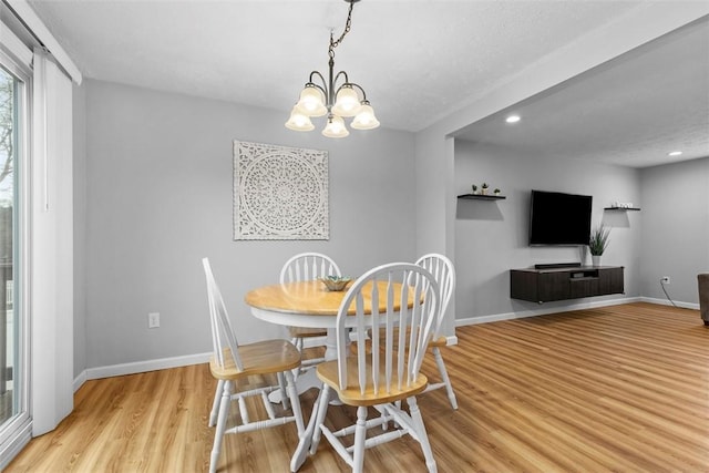 dining space featuring an inviting chandelier and light hardwood / wood-style flooring