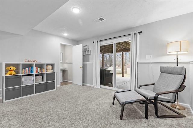 sitting room with carpet flooring and a textured ceiling