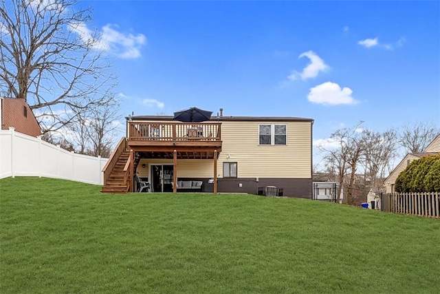 rear view of property featuring a wooden deck and a lawn