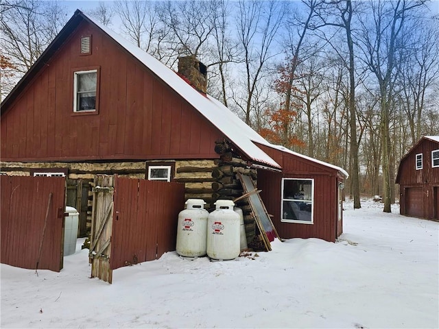 view of snow covered exterior featuring an outbuilding