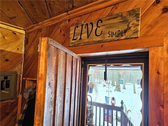 interior details with wooden ceiling, electric panel, and wood walls