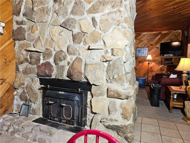 interior details featuring wooden walls, wood ceiling, and a wood stove