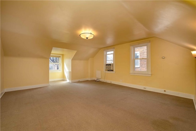 additional living space with carpet floors, lofted ceiling, and baseboards