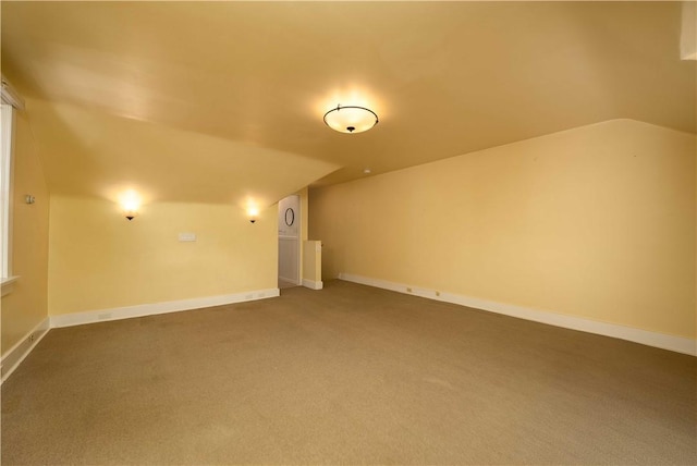 additional living space with carpet floors, baseboards, and vaulted ceiling