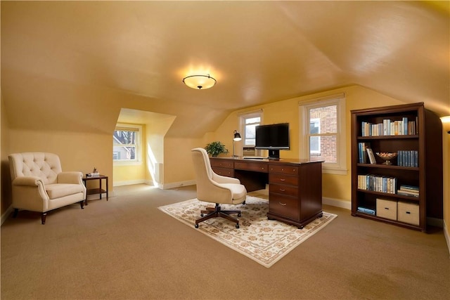 home office featuring plenty of natural light, vaulted ceiling, and light colored carpet